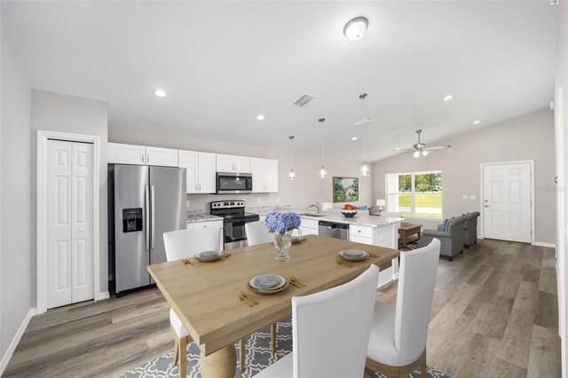 dining space featuring vaulted ceiling, light wood-type flooring, and ceiling fan