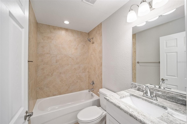 full bathroom featuring vanity, toilet, tiled shower / bath combo, and a textured ceiling