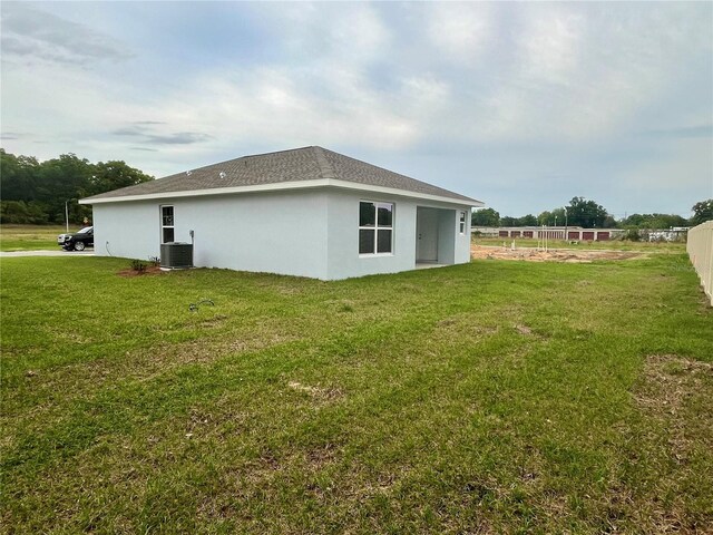 10816 SE 66th Ave, Belleview, FL 34420 - view of home's exterior with central AC unit, stucco siding, a yard, and fence