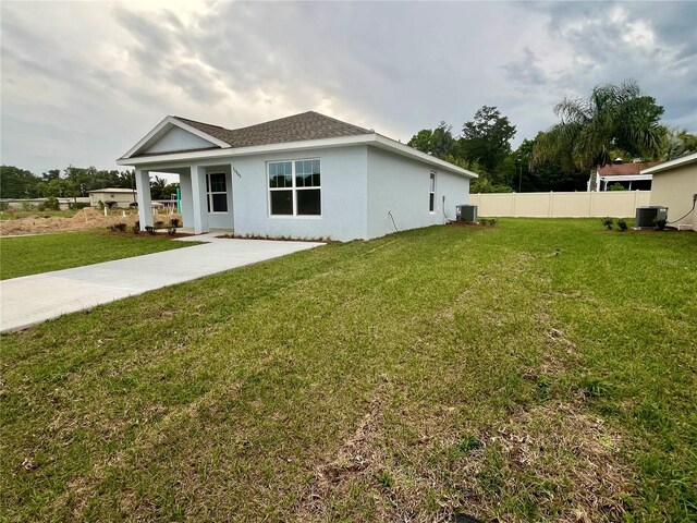 10816 SE 66th Ave, Belleview, FL 34420 - back of house with a yard, central AC, and stucco siding