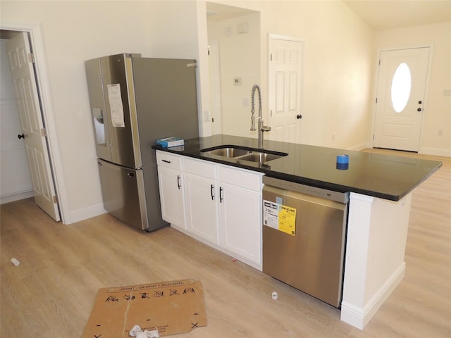 kitchen with white cabinets, light hardwood / wood-style floors, sink, and appliances with stainless steel finishes