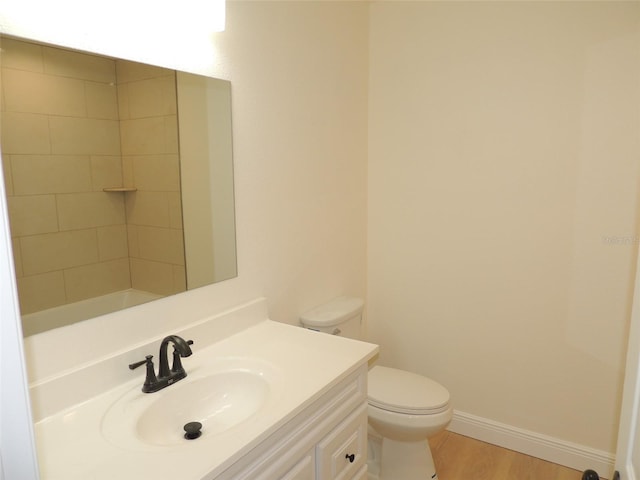 bathroom with toilet, vanity, and wood-type flooring