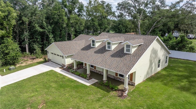 view of front of property featuring covered porch, a front yard, and a garage