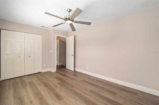 unfurnished bedroom featuring ceiling fan, light wood-type flooring, and a closet