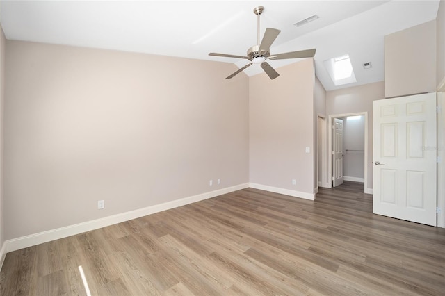 unfurnished bedroom featuring a skylight, a spacious closet, a closet, and wood-type flooring