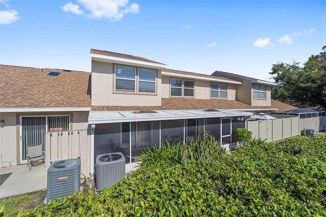 rear view of property with a sunroom and cooling unit