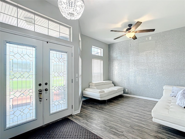 entryway featuring ceiling fan with notable chandelier, french doors, and dark hardwood / wood-style flooring