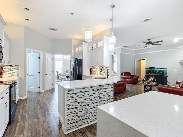 kitchen featuring white cabinets, tasteful backsplash, decorative light fixtures, dark wood-type flooring, and black appliances