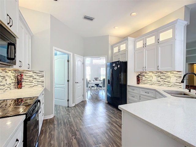 kitchen featuring sink, backsplash, white cabinetry, black appliances, and dark hardwood / wood-style flooring