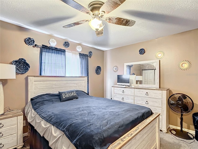 carpeted bedroom featuring ceiling fan and a textured ceiling