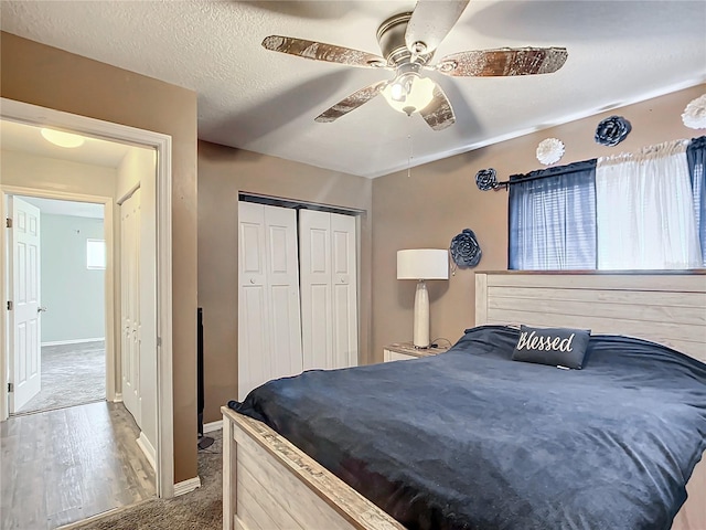 carpeted bedroom featuring ceiling fan, a textured ceiling, a closet, and a fireplace