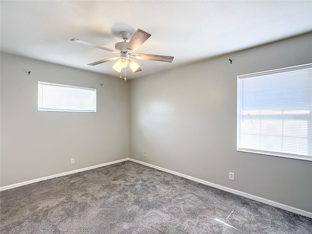 empty room with dark colored carpet and ceiling fan