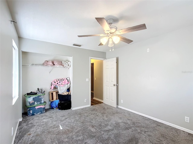 bedroom with ceiling fan, a closet, and dark colored carpet