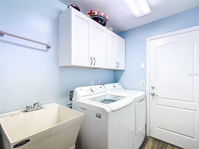 washroom featuring cabinets, separate washer and dryer, sink, and dark hardwood / wood-style flooring