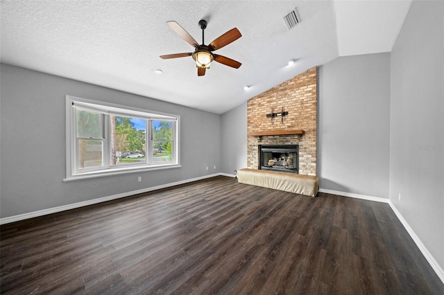 unfurnished living room with dark wood-type flooring, vaulted ceiling, a fireplace, and a textured ceiling