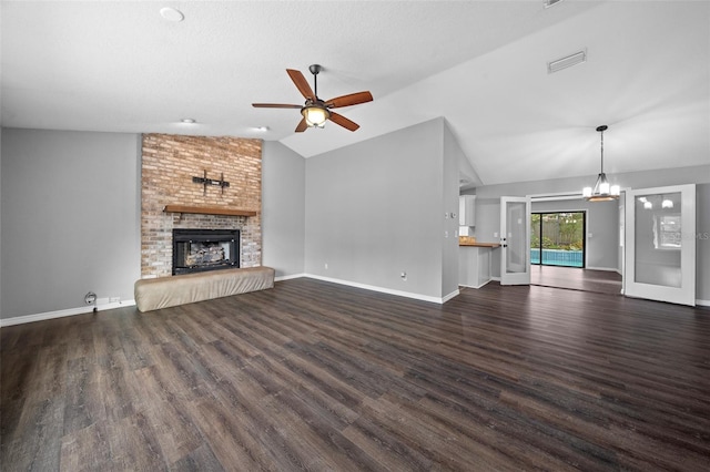 unfurnished living room with lofted ceiling, dark wood-type flooring, a fireplace, and ceiling fan