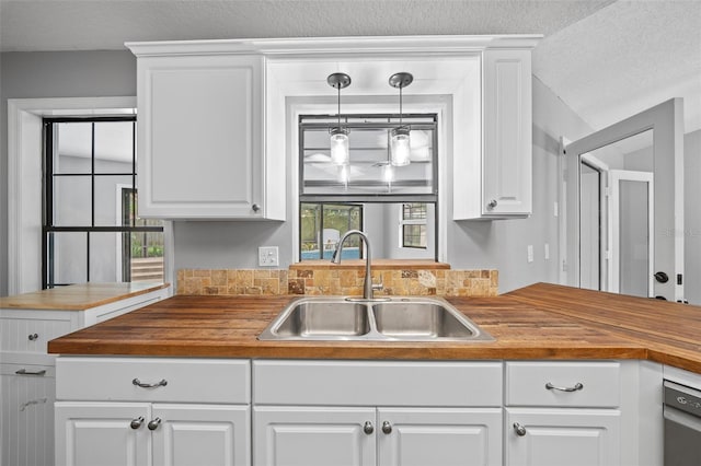 kitchen with white cabinetry, decorative light fixtures, sink, and dishwasher