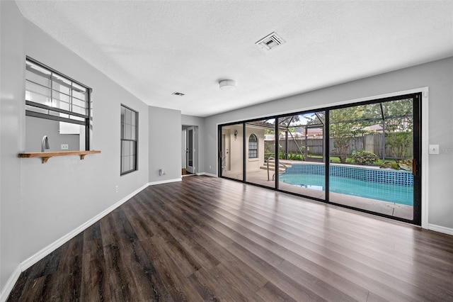 empty room featuring hardwood / wood-style flooring and a textured ceiling