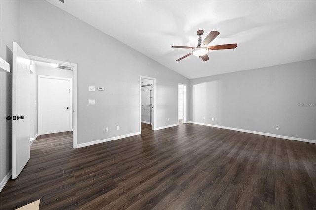 interior space with dark hardwood / wood-style floors, a spacious closet, vaulted ceiling, and ceiling fan