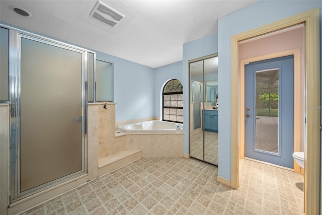 full bathroom with vanity, toilet, a textured ceiling, and plus walk in shower