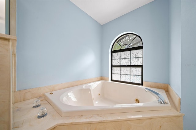 bathroom featuring a bathtub and vaulted ceiling