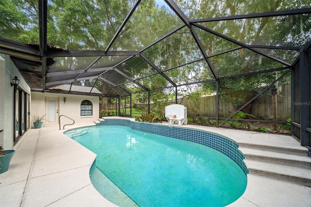 view of swimming pool featuring a patio area and a lanai