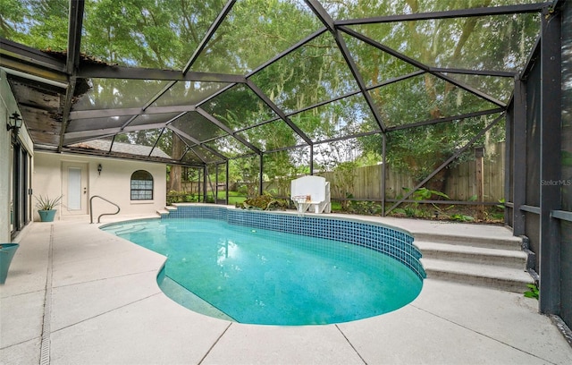 view of pool with a patio and glass enclosure