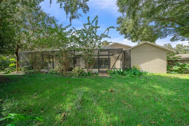 back of property with a lanai and a lawn