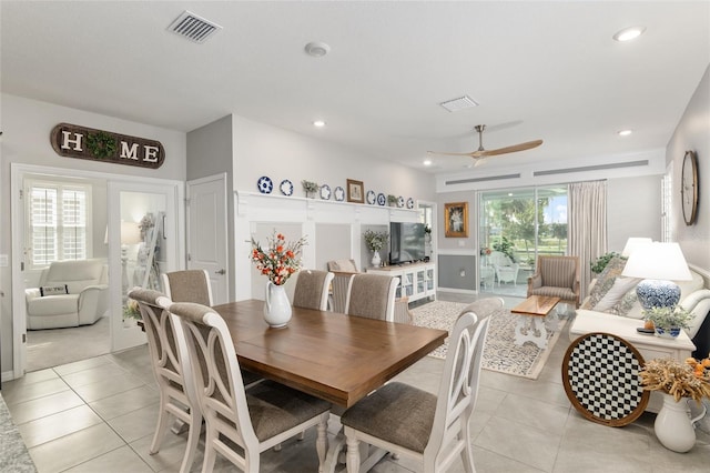 tiled dining area with ceiling fan and plenty of natural light