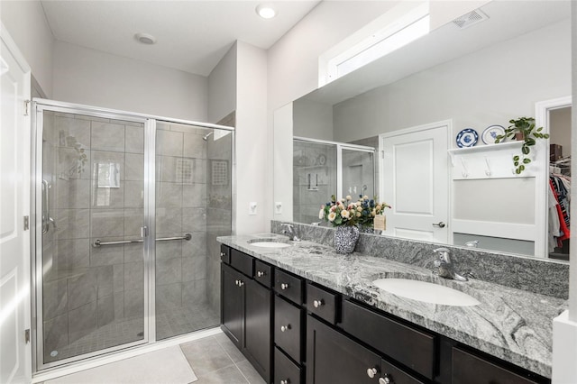 bathroom featuring a shower with door, tile patterned floors, and vanity