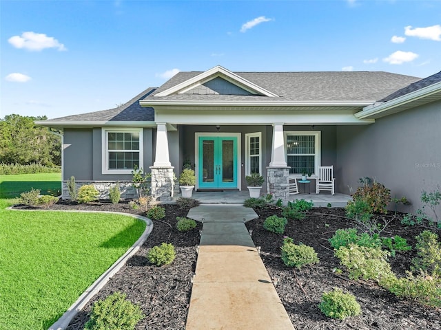 view of front of house featuring a porch, french doors, and a front lawn