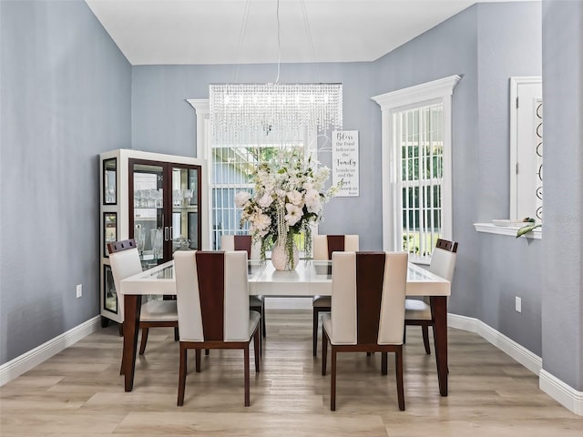 dining room featuring a chandelier, light hardwood / wood-style floors, and a healthy amount of sunlight