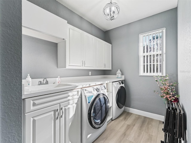 clothes washing area with cabinets, sink, light hardwood / wood-style flooring, separate washer and dryer, and a notable chandelier