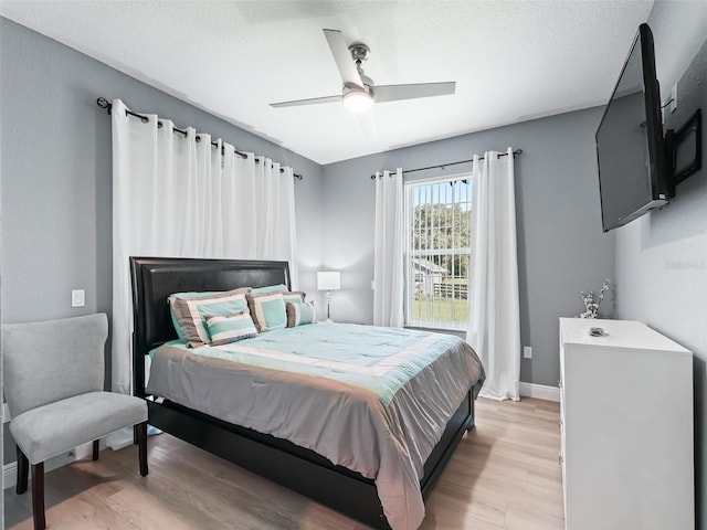 bedroom with ceiling fan, a textured ceiling, and light hardwood / wood-style flooring