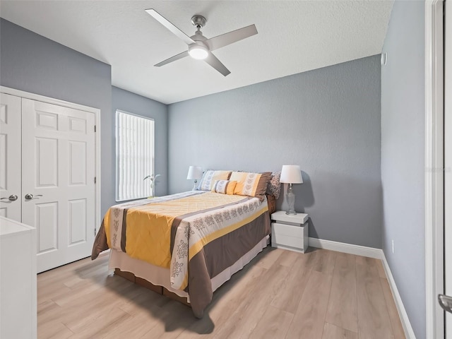 bedroom featuring light wood-type flooring, a closet, and ceiling fan