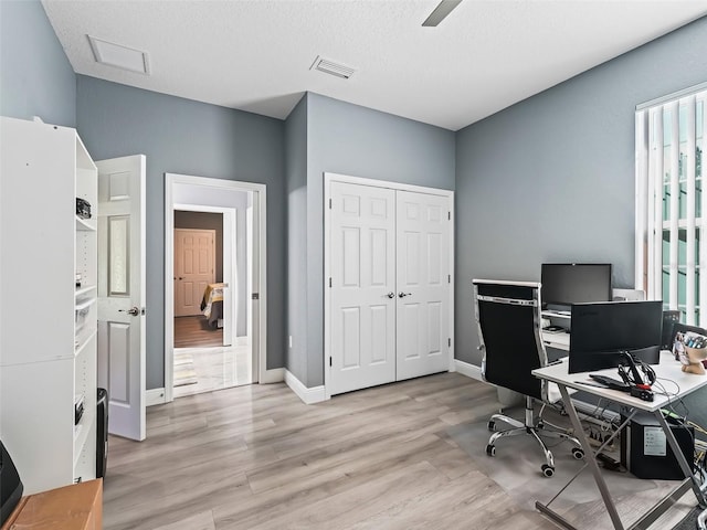 office area featuring ceiling fan, light hardwood / wood-style floors, and a textured ceiling