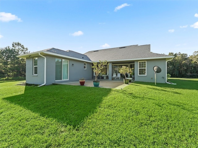 back of property with a yard and a patio