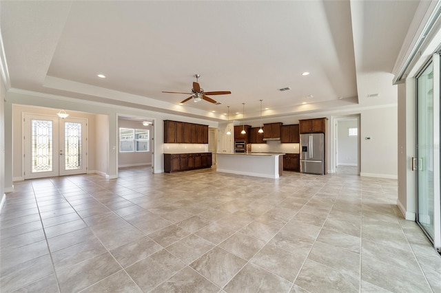 unfurnished living room with a raised ceiling, french doors, ornamental molding, and ceiling fan