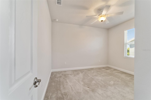 empty room featuring a textured ceiling, ceiling fan, and light colored carpet