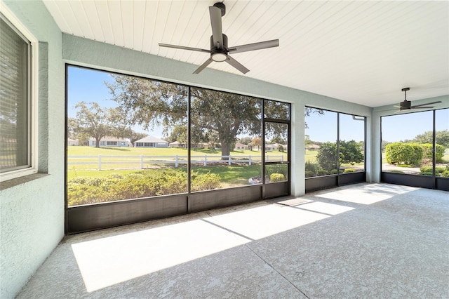 unfurnished sunroom featuring ceiling fan