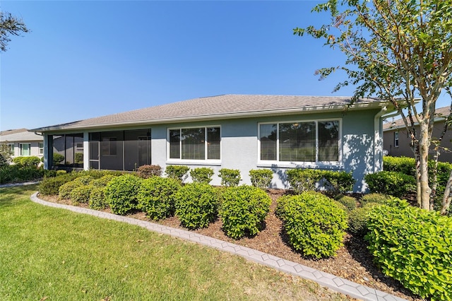 view of property exterior featuring a sunroom and a yard