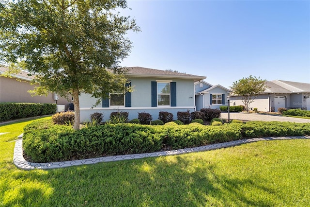 single story home featuring a garage and a front lawn