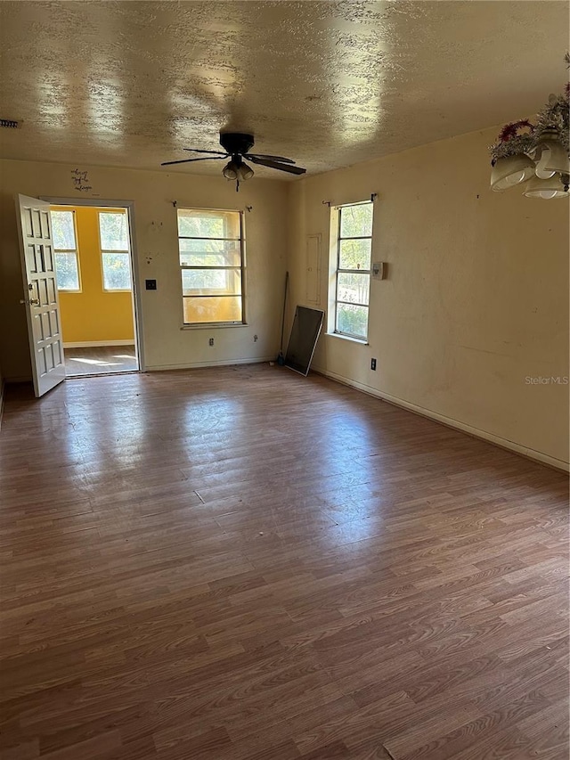 empty room featuring dark wood-type flooring, ceiling fan, and a textured ceiling