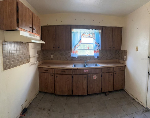 kitchen with light tile patterned flooring, sink, and backsplash