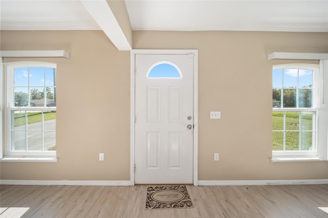 foyer entrance featuring light hardwood / wood-style floors and beam ceiling