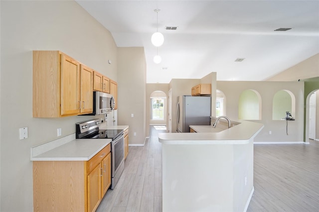 kitchen featuring light wood-type flooring, light brown cabinets, pendant lighting, vaulted ceiling, and appliances with stainless steel finishes