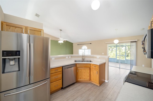 kitchen featuring ceiling fan, lofted ceiling, sink, appliances with stainless steel finishes, and light hardwood / wood-style floors