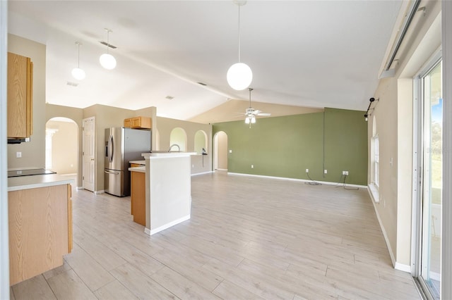 kitchen featuring stainless steel fridge, ceiling fan, light hardwood / wood-style flooring, vaulted ceiling, and hanging light fixtures