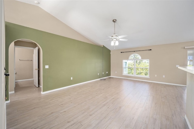 empty room with lofted ceiling, ceiling fan, and light hardwood / wood-style floors