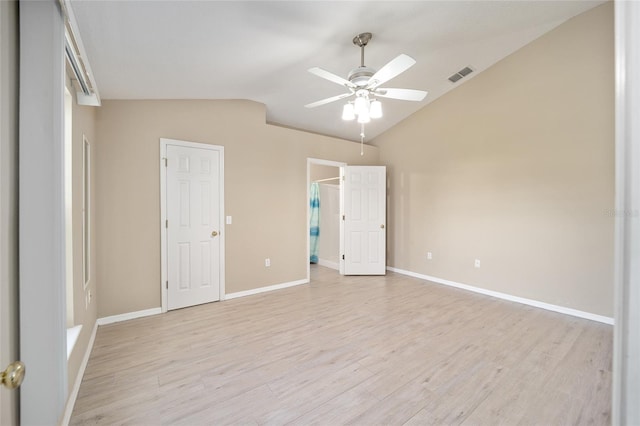 unfurnished bedroom featuring ceiling fan, light wood-type flooring, and vaulted ceiling